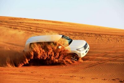 Desert Safari Dubai with Camel Ride, Sandboarding & Dinner - Hotel pickup in 4x4, then out toward the desert and Hajjar Mountains