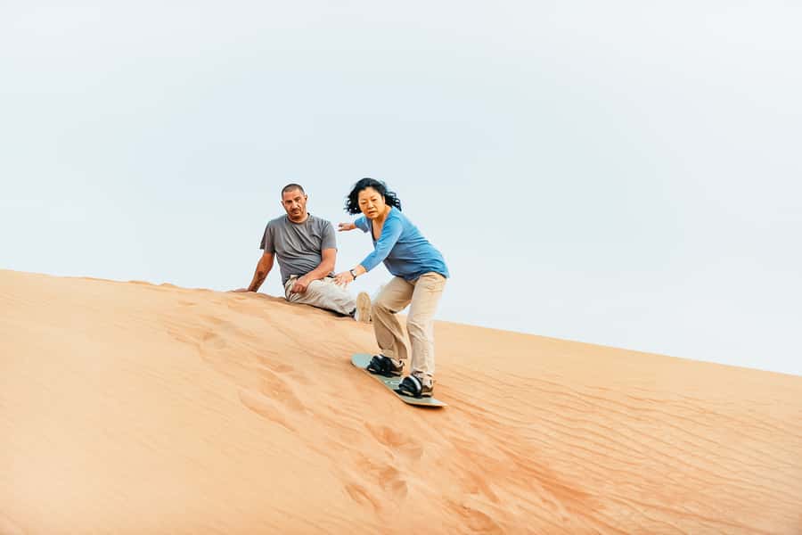 Doha: Desert Safari Dune Bashing, Sandboarding, & Camel Ride - Sandboarding at the desert-beach edge: fun, not a skill test