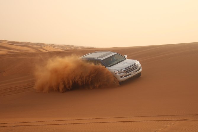 Dubai Desert Safari, Evening at Red-Dunes, 5<em> BBQ Dinner – Stop 2: Desert Road Tours Camp and The Evening Show Lineup’ /><br />
Once you’re at the camp, the evening becomes a show-and-meal setup. The program includes multiple performances:</p>
<ul>
<li><strong>Tanoura dance</strong></li>
<li><strong>Fire show</strong></li>
<li><strong>Belly dance</strong></li>
</ul>
<p><p>There’s an important Ramadan note: <strong>no belly dance is performed during Ramadan month</strong>. If you’re visiting during that time, you’ll still get the other entertainment elements, just without the belly dance segment.</p>
</p>
<p><p>This entertainment mix is a good match for an evening safari because it gives you contrast. Tanoura and fire performances look best when the sky is dark. Belly dance (when included) adds a different rhythm to the show lineup and often becomes the part people talk about afterward.</p>
</p>
<p><p>Timing wise, you can expect the camp entertainment to run while you’re also eating. That’s why I like this format: it prevents the usual problem where dinner happens and then you’re left waiting for entertainment that starts late.</p>
</p>
<h2 id="the-bbq-dinner-buffet-style-international-with-veg-options">The BBQ Dinner: Buffet-Style, International, With Veg Options</h2>
<p> BBQ Dinner – The BBQ Dinner: Buffet-Style, International, With Veg Options’ /><br />
Dinner is one of the strongest value points in this package. You get <strong>a live BBQ international buffet</strong> with <strong>non-veg and veg</strong> options. Vegetarian travelers aren’t left guessing here, because the dinner explicitly includes both categories.</p>
<p><p>You also get steady drink support during the meal:</p>
</p>
<ul>
<li><strong>welcome drink</strong></li>
<li><strong>soft drinks</strong></li>
<li><strong>tea and coffee (unlimited)</strong></li>
</ul>
<p><p>There are also snacks included such as <strong>Arabic sweets (Gaymat)</strong>, <strong>Arabic coffee (Gahwa)</strong>, and <strong>dates</strong>. This is the kind of small included touch that makes the camp feel less like a conveyor-belt meal and more like a themed evening.</p>
</p>
<p><p>Two practical notes:</p>
</p>
<ul>
<li><strong>Alcoholic drinks are not included</strong>. They are available to purchase.</li>
<li><strong>Table service is not included</strong>, so expect a self-serve buffet setup rather than being waited on at your seat.</li>
</ul>
<h2 id="price-and-value-why-134-can-make-sense-here">Price and Value: Why $134 Can Make Sense Here</h2>
<p>At <strong>$134 per person</strong>, the question is not whether the safari is expensive. The question is what you’re actually buying.</p>
<p><p>You’re not just paying for one thrill. This package includes multiple activities that most add-ons normally cost extra:</p>
</p>
<ul>
<li><strong>dune bashing in a 4×4 Land Cruiser</strong></li>
<li><strong>sandboarding</strong></li>
<li><strong>camel ride</strong></li>
<li><strong>henna design</strong></li>
<li><strong>sunset photography</strong></li>
<li>camp entertainment (Tanoura, fire, and sometimes belly dance)</li>
<li><strong>BBQ dinner buffet</strong> with <strong>veg options</strong></li>
<li><strong>unlimited tea/coffee</strong> and soft drinks</li>
</ul>
<p><p>That bundled feel is why people often recommend this type of group safari to first-time visitors. You get a full evening that hits the main Dubai desert-safari boxes without you doing planning math.</p>
</p>
<p><p>The tradeoff is the group format. With <strong>a maximum of 200 travelers</strong>, the camp can be set up for a crowd. That doesn’t ruin the experience, but it does mean you should expect a structured schedule rather than a slow, quiet desert night.</p>
</p>
<h2 id="practical-tips-that-actually-help-on-sand-days">Practical Tips That Actually Help On Sand Days</h2>
<p>I’ll keep this practical and simple, because the desert is less forgiving than a city sidewalk.</p>
<p><p>First, plan your timing mindset. The evening is packed, and you’ll bounce between transport, dunes, and camp activities. You’ll enjoy it more if you go in knowing it’s a “program night,” not a long stay.</p>
</p>
<p><p>Second, dress for sand. Your clothes will likely get dusty during dune activities and sandboarding. Choose what you’re okay with getting gritty, and keep a change plan if you’re going somewhere right after.</p>
</p>
<p><p>Third, hydrate smartly. You’ll be drinking during dinner (soft drinks plus tea/coffee), but it helps to pace water earlier too. Desert evenings still feel dry, especially after a day in the city.</p>
</p>
<p><p>Finally, treat the driver and safety instructions as part of the fun. The best dune bashing experiences are the ones where the vehicle handling is confident and everyone stays calm.</p>
</p>
<h2 id="who-this-dubai-desert-safari-fits-best">Who This Dubai Desert Safari Fits Best</h2>
<p>This tour fits best if you want an all-in-one <strong>Dubai desert safari evening</strong> with a mix of adrenaline and camp culture.</p>
<p><p>You’ll probably like it if:</p>
</p>
<ul>
<li>you want <strong>pickup and drop-off</strong>, so you don’t spend time figuring logistics</li>
<li>you want multiple activities in one evening (not just dinner and a short show)</li>
<li>you’re traveling as a couple, family, or group and prefer organized pacing</li>
<li>you care about <strong>vegetarian dinner options</strong></li>
</ul>
<p><p>You might want to skip it (or consider a more private option) if:</p>
</p>
<ul>
<li>you dislike sharing a camp environment with a larger group</li>
<li>you want total control of timings and activities</li>
<li>you’re specifically hunting for a longer buggy or ATV session than a 30-minute window</li>
</ul>
<h2 id="should-you-book-this-red-dunes-bbq-dinner-safari">Should You Book This Red-Dunes BBQ Dinner Safari?</h2>
<p>If you want a classic Dubai desert night that runs smoothly from <strong>3:00 pm</strong> through dinner and shows, I’d book it. The inclusion list is strong: <strong>dune bashing, sandboarding, camel ride, henna, a full buffet BBQ, and evening entertainment</strong> all in one package.</p>
<p><p>The decision comes down to your tolerance for a crowd. If you can enjoy a lively camp atmosphere and structured timing, this is a solid value at <strong>$134</strong>. If you want a quieter, more customized experience with more space and less schedule pressure, you’ll likely prefer a private format.</p>
</p>
<p><p>Either way, the biggest difference-maker is your driver. The names that often show up as standout guides during planning include Ashraf Shobi, Sijin Abraham, Bandari, and Nanndan Singh, and that’s a good sign that the operation emphasizes safety and comfort.</p>
</p>
<h2 id="faq">FAQ</h2>
<h3 id="what-time-does-the-desert-safari-start">What time does the desert safari start?</h3>
<p>It starts at <strong>3:00 pm</strong> and runs as an evening activity in Dubai.</p>
<h3 id="how-long-is-the-tour">How long is the tour?</h3>
<p>Plan for <strong>about 6 to 7 hours</strong> total.</p>
<h3 id="do-you-get-pickup-and-drop-off-in-dubai">Do you get pickup and drop-off in Dubai?</h3>
<p>Yes. <strong>Pickup and drop facilities</strong> from your hotel or location are included.</p>
<h3 id="what-activities-are-included-at-the-desert-camp">What activities are included at the desert camp?</h3>
<p>At the camp you can do a <strong>short camel ride</strong> and get <strong>henna design painting</strong>, and you’ll also enjoy <strong>entertainment shows</strong> plus <strong>BBQ dinner</strong>.</p>
<h3 id="are-sandboarding-and-dune-bashing-included">Are sandboarding and dune bashing included?</h3>
<p>Yes. The package includes <strong>sand-boarding</strong> and <strong>dune bashing</strong> in a fully air-conditioned <strong>4×4 Land Cruiser</strong>.</p>
<h3 id="is-there-vegetarian-food-at-the-bbq-dinner">Is there vegetarian food at the BBQ dinner?</h3>
<p>Yes. Dinner is a <strong>live BBQ international buffet</strong> with <strong>non-veg / veg</strong> options.</p>
<h3 id="is-belly-dance-included-during-ramadan">Is belly dance included during Ramadan?</h3>
<p>During <strong>Ramadan month</strong>, the tour states that there is <strong>no belly dance</strong>, while other entertainment remains part of the program.</p>
<h3 id="are-alcoholic-drinks-or-sheesha-included">Are alcoholic drinks or sheesha included?</h3>
<p>No. <strong>Alcoholic drinks are not included</strong> (they’re available to purchase), and <strong>sheesha smoking is not included</strong>.</p>
<h3 id="can-i-cancel-for-a-full-refund">Can I cancel for a full refund?</h3>
<p>Yes, you can <strong>cancel for free</strong> up to <strong>24 hours in advance</strong> for a full refund. If you cancel less than 24 hours before the start time, the amount paid is not refunded.</p>
</div><aside class="bts-post-sidebar"> <div class="bts-booking">
<a class="bts-booking-image" href="https://www.viator.com/tours/Dubai/Evening-Red-Dunes-Desert-Safari/d828-103429P1" target="_blank" rel="nofollow noopener sponsored" aria-label="Dubai Desert Safari, Evening at Red-Dunes, 5* BBQ Dinner">
<img decoding="async" src="https://3.bookthatsafari.com/wp-content/uploads/dubai-desert-safari-evening-at-red-dunes-5-bbq-dinner.jpg" alt="" loading="lazy" />
</a>
<div class="bts-booking-body">
<p class="bts-booking-platform">Official tickets via <strong>Viator</strong></p>
<p class="bts-booking-price">From <strong>$134.00</strong> <span>per person</span></p>
<p class="bts-booking-section-label">Check Availability</p>
<div class="bts-booking-dates">
<a class="bts-booking-date bts-booking-date--today" href="https://www.viator.com/tours/Dubai/Evening-Red-Dunes-Desert-Safari/d828-103429P1" target="_blank" rel="nofollow noopener sponsored">
<span class="day">Sat</span>
<span class="date">1 Aug</span>
</a>
<a class="bts-booking-date" href="https://www.viator.com/tours/Dubai/Evening-Red-Dunes-Desert-Safari/d828-103429P1" target="_blank" rel="nofollow noopener sponsored">
<span class="day">Sun</span>
<span class="date">2 Aug</span>
</a>
<a class="bts-booking-date" href="https://www.viator.com/tours/Dubai/Evening-Red-Dunes-Desert-Safari/d828-103429P1" target="_blank" rel="nofollow noopener sponsored">
<span class="day">Mon</span>
<span class="date">3 Aug</span>
</a>
<a class="bts-booking-date" href="https://www.viator.com/tours/Dubai/Evening-Red-Dunes-Desert-Safari/d828-103429P1" target="_blank" rel="nofollow noopener sponsored">
<span class="day">Tue</span>
<span class="date">4 Aug</span>
</a>
<a class="bts-booking-date bts-booking-date--more" href="https://www.viator.com/tours/Dubai/Evening-Red-Dunes-Desert-Safari/d828-103429P1" target="_blank" rel="nofollow noopener sponsored" aria-label="See all dates">
<svg width="18" height="18" viewBox="0 0 24 24" fill="none" stroke="currentColor" stroke-width="2" stroke-linecap="round" stroke-linejoin="round" aria-hidden="true">
<rect x="3" y="4" width="18" height="18" rx="2" ry="2"></rect>
<line x1="16" y1="2" x2="16" y2="6"></line>
<line x1="8" y1="2" x2="8" y2="6"></line>
<line x1="3" y1="10" x2="21" y2="10"></line>
</svg>
</a>
</div>
<a class="bts-booking-cta" href="https://www.viator.com/tours/Dubai/Evening-Red-Dunes-Desert-Safari/d828-103429P1" target="_blank" rel="nofollow noopener sponsored">Book on Viator →</a>
<p class="bts-booking-rating">
<span class="bts-stars" aria-label="Rating: 5.0 out of 5">
<span class="bts-stars-bg" aria-hidden="true">★★★★★</span>
<span class="bts-stars-fg" aria-hidden="true" style="width: 100%">★★★★★</span>
</span>
<strong>5.0</strong>
<span class="reviews">(213 reviews)</span> </p>
<p class="bts-booking-note">Reviewed by Book That Safari.<br>Booking through Viator.</p>
</div>
</div>
</aside></div><div class="sb-related-posts"><h3>You Might Also Enjoy</h3><div class="sb-related-grid"><a href="https://bookthatsafari.com/desert-safari-tour-quad-bike-with-bbq-dinner-show-from-dubai/" class="sb-related-item"><img decoding="async" width="300" height="200" src="https://3.bookthatsafari.com/wp-content/uploads/desert-safari-tour-quad-bike-with-bbq-dinner-show-from-dubai-400x267.jpg" class="attachment-medium size-medium wp-post-image" alt="Desert Safari Tour, Quad Bike with BBQ Dinner & Show from Dubai - Sandboarding and the sunset photo stop: when the desert looks its best" loading="lazy" srcset="https://3.bookthatsafari.com/wp-content/uploads/desert-safari-tour-quad-bike-with-bbq-dinner-show-from-dubai-400x267.jpg 400w, https://3.bookthatsafari.com/wp-content/uploads/desert-safari-tour-quad-bike-with-bbq-dinner-show-from-dubai.jpg 669w" sizes="auto, (max-width: 300px) 100vw, 300px" /><span>Desert Safari Tour, Quad Bike with BBQ Dinner & Show from Dubai</span></a><a href="https://bookthatsafari.com/sharm-el-sheikh-quad-bike-safari-camel-with-dinner-show/" class="sb-related-item"><img decoding="async" width="300" height="149" src="https://3.bookthatsafari.com/wp-content/uploads/sharm-el-sheikh-quad-bike-safari-camel-with-dinner-show-400x199.jpg" class="attachment-medium size-medium wp-post-image" alt="Sharm El Sheikh: Quad bike, Safari, Camel With Dinner & Show - How the Afternoon Flows: Pickup, Desert Dunes, and Sunset Timing" loading="lazy" srcset="https://3.bookthatsafari.com/wp-content/uploads/sharm-el-sheikh-quad-bike-safari-camel-with-dinner-show-400x199.jpg 400w, https://3.bookthatsafari.com/wp-content/uploads/sharm-el-sheikh-quad-bike-safari-camel-with-dinner-show.jpg 900w" sizes="auto, (max-width: 300px) 100vw, 300px" /><span>Sharm El Sheikh: Quad bike, Safari, Camel With Dinner & Show</span></a><a href="https://bookthatsafari.com/crete-land-rover-safari-on-minoan-route/" class="sb-related-item"><img decoding="async" width="300" height="156" src="https://3.bookthatsafari.com/wp-content/uploads/crete-land-rover-safari-on-minoan-route-400x208.jpg" class="attachment-medium size-medium wp-post-image" alt="Crete: Land Rover Safari on Minoan Route - Pickup in Piskopiano and What to Expect from the 8-Hour Flow" loading="lazy" srcset="https://3.bookthatsafari.com/wp-content/uploads/crete-land-rover-safari-on-minoan-route-400x208.jpg 400w, https://3.bookthatsafari.com/wp-content/uploads/crete-land-rover-safari-on-minoan-route.jpg 900w" sizes="auto, (max-width: 300px) 100vw, 300px" /><span>Crete: Land Rover Safari on Minoan Route</span></a><a href="https://bookthatsafari.com/desert-combo-safari-camel-ride-quad-bike-and-dune-bashingall-inclusive/" class="sb-related-item"><img decoding="async" width="300" height="200" src="https://3.bookthatsafari.com/wp-content/uploads/desert-combo-safari-camel-ride-quad-bike-and-dune-bashing-all-inclusive-400x267.jpg" class="attachment-medium size-medium wp-post-image" alt="Desert Combo safari, Camel ride, Quad Bike and Dune Bashing(ALL INCLUSIVE) - From Sealine Beach Out to the Dunes: Your ATV Quad Bike Block" loading="lazy" srcset="https://3.bookthatsafari.com/wp-content/uploads/desert-combo-safari-camel-ride-quad-bike-and-dune-bashing-all-inclusive-400x267.jpg 400w, https://3.bookthatsafari.com/wp-content/uploads/desert-combo-safari-camel-ride-quad-bike-and-dune-bashing-all-inclusive.jpg 669w" sizes="auto, (max-width: 300px) 100vw, 300px" /><span>Desert Combo safari, Camel ride, Quad Bike and Dune Bashing(ALL INCLUSIVE)</span></a></div></div><div style="margin: 20px 0; padding: 15px 0;"><h3>More Tour Reviews in Dubai</h3><ul style="margin: 10px 0; padding: 0; list-style: none;"><li style="margin: 0 0 10px 0; padding: 0 0 10px 0; border-bottom: 1px solid #eee; display: flex; align-items: flex-start; gap: 12px; line-height: 1.4;"><a href="https://bookthatsafari.com/dubai-desert-safari-quad-bike-camel-ride-al-khayma-camp/" aria-hidden="true" tabindex="-1"><img decoding="async" style="width: 80px; height: 60px; object-fit: cover; border-radius: 4px; flex-shrink: 0;" src="https://3.bookthatsafari.com/wp-content/uploads/dubai-desert-safari-quad-bike-camel-ride-al-khayma-camp-150x150.jpg" alt="" loading="lazy"></a><div><a href="https://bookthatsafari.com/dubai-desert-safari-quad-bike-camel-ride-al-khayma-camp/">Dubai: Desert Safari, Quad Bike, Camel Ride & Al Khayma Camp</a><br><span style="font-size: 0.82em; color: #555; margin-top: 2px;"><span style="color: #f5a623;">★</span> 4.9 · 68,962 reviews</span></div></li><li style="margin: 0 0 10px 0; padding: 0 0 10px 0; border-bottom: 1px solid #eee; display: flex; align-items: flex-start; gap: 12px; line-height: 1.4;"><a href="https://bookthatsafari.com/dubai-desert-safari-quad-bike-camel-ride-and-sandboarding/" aria-hidden="true" tabindex="-1"><img decoding="async" style="width: 80px; height: 60px; object-fit: cover; border-radius: 4px; flex-shrink: 0;" src="https://3.bookthatsafari.com/wp-content/uploads/dubai-desert-safari-quad-bike-camel-ride-and-sandboarding-150x150.jpg" alt="" loading="lazy"></a><div><a href="https://bookthatsafari.com/dubai-desert-safari-quad-bike-camel-ride-and-sandboarding/">Dubai: Desert Safari, Quad Bike, Camel Ride and Sandboarding</a><br><span style="font-size: 0.82em; color: #555; margin-top: 2px;"><span style="color: #f5a623;">★</span> 4.9 · 43,505 reviews</span></div></li><li style="margin: 0 0 10px 0; padding: 0 0 10px 0; border-bottom: 1px solid #eee; display: flex; align-items: flex-start; gap: 12px; line-height: 1.4;"><a href="https://bookthatsafari.com/dubai-safari-quad-bike-camel-ride-and-buffet-dinner/" aria-hidden="true" tabindex="-1"><img decoding="async" style="width: 80px; height: 60px; object-fit: cover; border-radius: 4px; flex-shrink: 0;" src="https://3.bookthatsafari.com/wp-content/uploads/dubai-safari-quad-bike-camel-ride-and-buffet-dinner-150x150.jpg" alt="" loading="lazy"></a><div><a href="https://bookthatsafari.com/dubai-safari-quad-bike-camel-ride-and-buffet-dinner/">Dubai: Safari, Quad Bike, Camel Ride, and Buffet Dinner</a><br><span style="font-size: 0.82em; color: #555; margin-top: 2px;"><span style="color: #f5a623;">★</span> 4.9 · 33,424 reviews</span></div></li><li style="margin: 0 0 10px 0; padding: 0 0 10px 0; border-bottom: 1px solid #eee; display: flex; align-items: flex-start; gap: 12px; line-height: 1.4;"><a href="https://bookthatsafari.com/dubai-red-dune-safari-quad-bike-camel-ride-bbq-dinner/" aria-hidden="true" tabindex="-1"><img decoding="async" style="width: 80px; height: 60px; object-fit: cover; border-radius: 4px; flex-shrink: 0;" src="https://3.bookthatsafari.com/wp-content/uploads/dubai-red-dune-safari-quad-bike-camel-ride-bbq-dinner-150x150.jpg" alt="" loading="lazy"></a><div><a href="https://bookthatsafari.com/dubai-red-dune-safari-quad-bike-camel-ride-bbq-dinner/">Dubai: Red Dune Safari, Quad Bike, Camel Ride, BBQ Dinner</a><br><span style="font-size: 0.82em; color: #555; margin-top: 2px;"><span style="color: #f5a623;">★</span> 4.9 · 32,185 reviews</span></div></li><li style="margin: 0 0 10px 0; padding: 0 0 10px 0; border-bottom: 1px solid #eee; display: flex; align-items: flex-start; gap: 12px; line-height: 1.4;"><a href="https://bookthatsafari.com/dubai-premium-safari-camel-ride-al-khayma-camp-3-buffets/" aria-hidden="true" tabindex="-1"><img decoding="async" style="width: 80px; height: 60px; object-fit: cover; border-radius: 4px; flex-shrink: 0;" src="https://3.bookthatsafari.com/wp-content/uploads/dubai-premium-safari-camel-ride-al-khayma-camp-3-buffets-150x150.jpg" alt="" loading="lazy"></a><div><a href="https://bookthatsafari.com/dubai-premium-safari-camel-ride-al-khayma-camp-3-buffets/">Dubai: Premium Safari, Camel Ride & Al Khayma Camp 3-Buffets</a><br><span style="font-size: 0.82em; color: #555; margin-top: 2px;"><span style="color: #f5a623;">★</span> 4.9 · 30,335 reviews</span></div></li><li style="margin: 0; padding: 0; border-bottom: none; display: flex; align-items: flex-start; gap: 12px; line-height: 1.4;"><a href="https://bookthatsafari.com/dubai-desert-safari-with-bbq-dinner-quad-biking-options/" aria-hidden="true" tabindex="-1"><img decoding="async" style="width: 80px; height: 60px; object-fit: cover; border-radius: 4px; flex-shrink: 0;" src="https://3.bookthatsafari.com/wp-content/uploads/dubai-desert-safari-with-bbq-dinner-quad-biking-options-150x150.jpg" alt="" loading="lazy"></a><div><a href="https://bookthatsafari.com/dubai-desert-safari-with-bbq-dinner-quad-biking-options/">Dubai: Desert Safari with BBQ Dinner & Quad Biking Options</a><br><span style="font-size: 0.82em; color: #555; margin-top: 2px;"><span style="color: #f5a623;">★</span> 4.9 · 20,485 reviews</span></div></li></ul></div><div style="margin: 20px 0; padding: 15px 0;"><h3>Not for you? Here